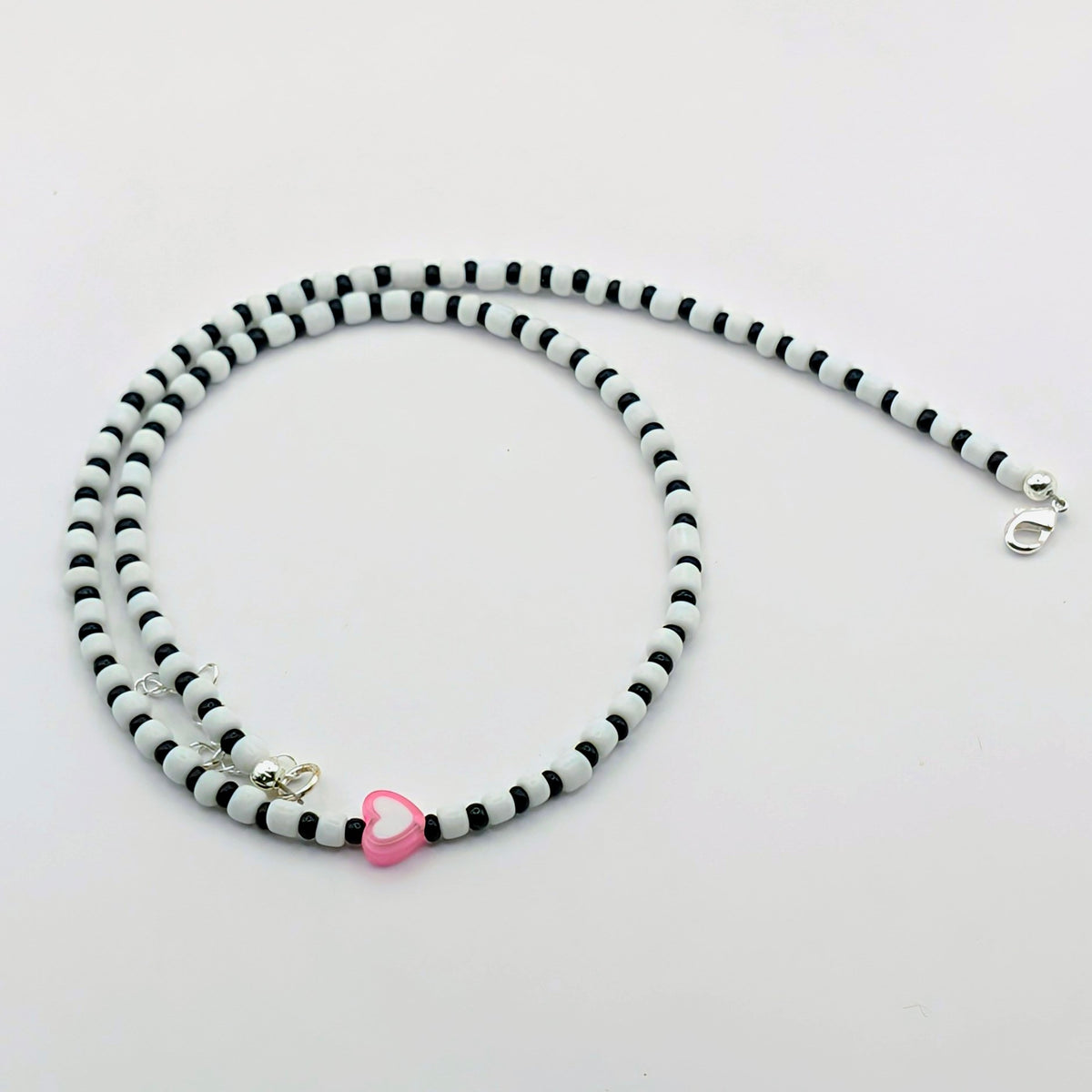 Sara quirky handmade necklace with black and white glass beads, pink and white heart bead, silver clasp and extension chain.
