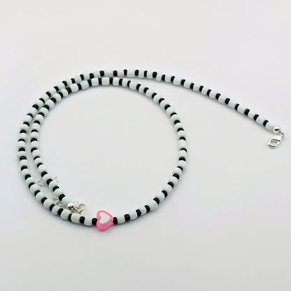 Sara quirky handmade necklace with black and white glass beads, pink and white heart bead, silver clasp and extension chain.