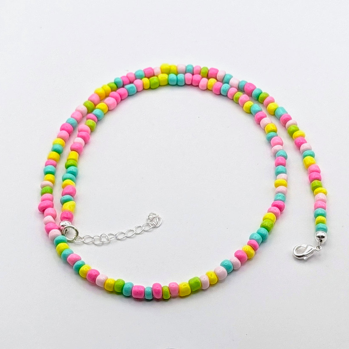 Fran handmade beaded necklace with colourful pink, aqua, yellow and green glass beads, silver clasp and extension chain.