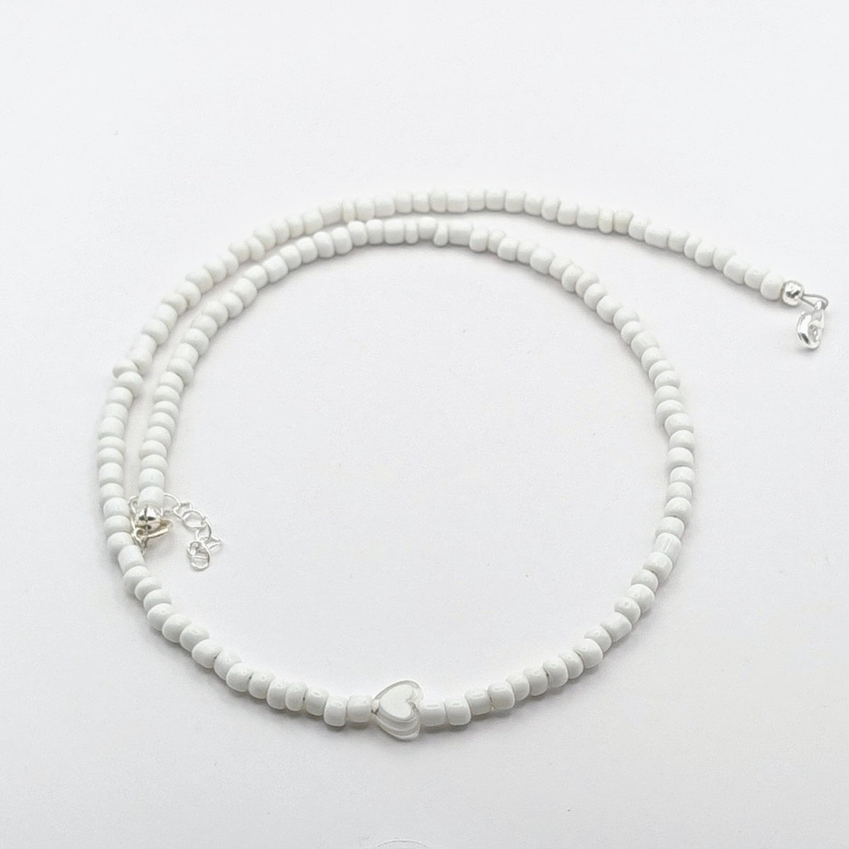 Sara handmade beaded necklace with white glass beads, translucent white heart bead and silver adjustable clasp and extension chain.
