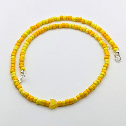 Sara colourful beaded necklace with yellow and golden glass beads, translucent yellow heart bead and silver adjustable hardware.