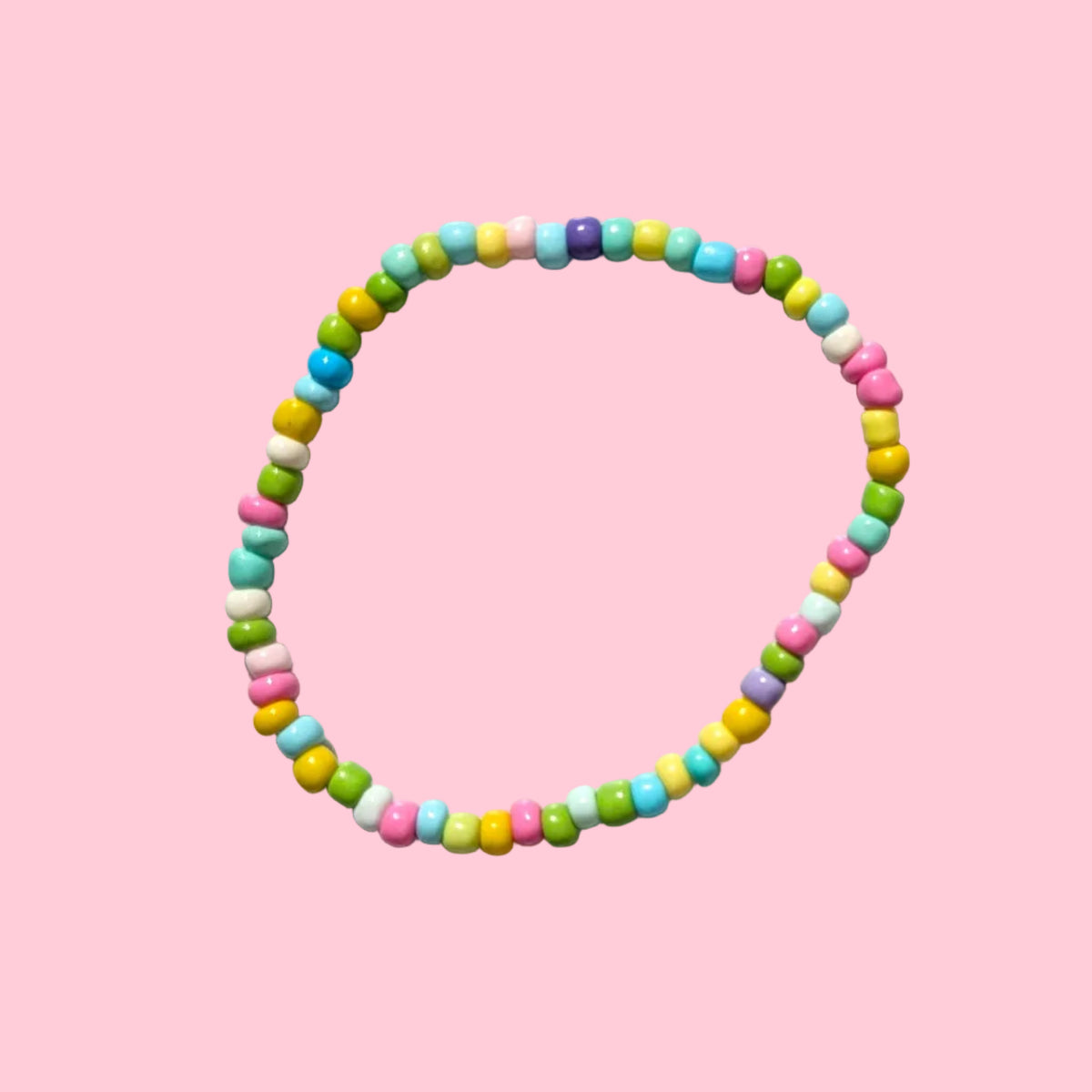 A beaded stretch bracelet made of small multicolor round beads, displayed on a textured white background.