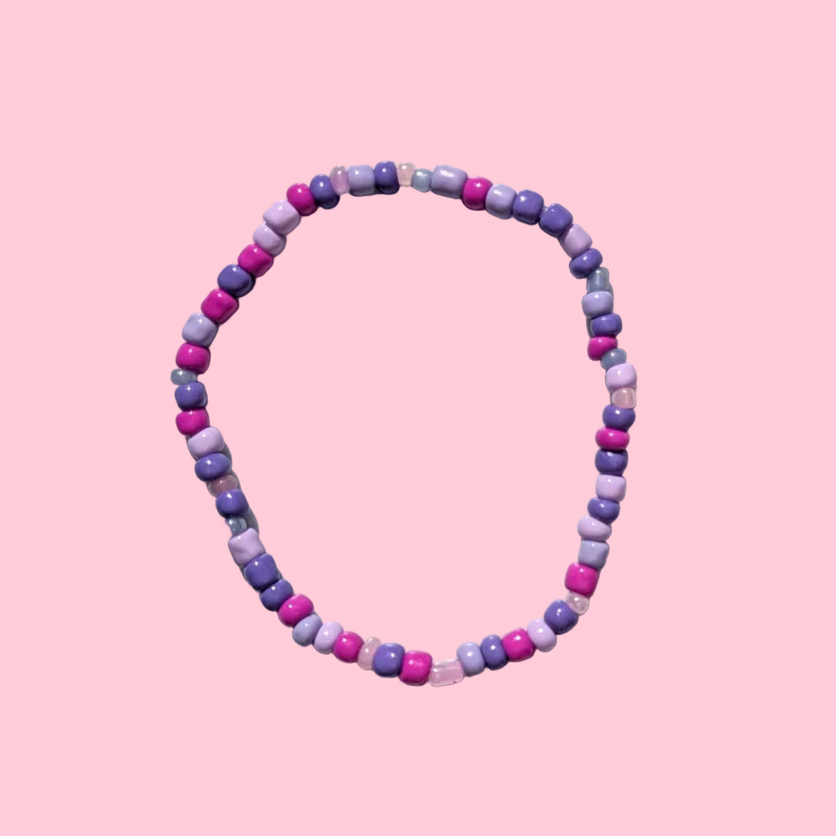 A beaded stretch bracelet made of small purple round beads, displayed on a textured white background.