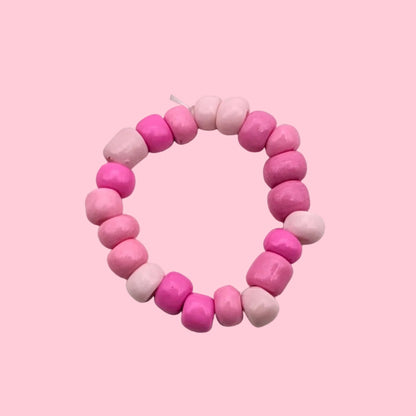 A beaded stretch ring featuring alternating pink and light pink round beads, displayed on a plain white background.