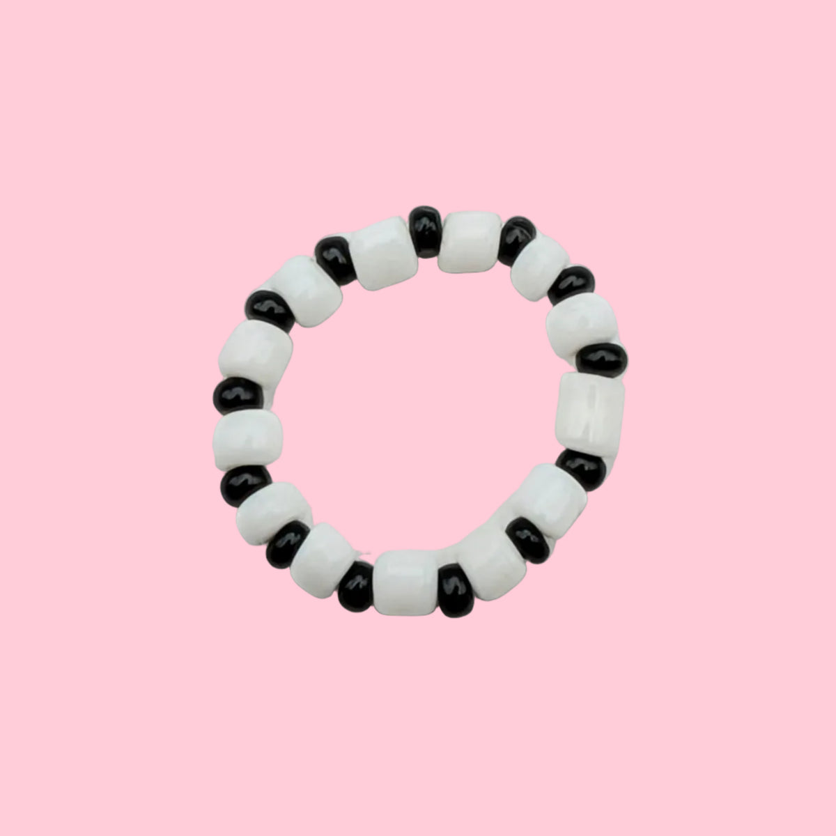 A beaded stretch ring bracelet featuring alternating white and black round beads, photographed on a plain white background.