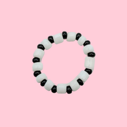 A beaded stretch ring bracelet featuring alternating white and black round beads, photographed on a plain white background.