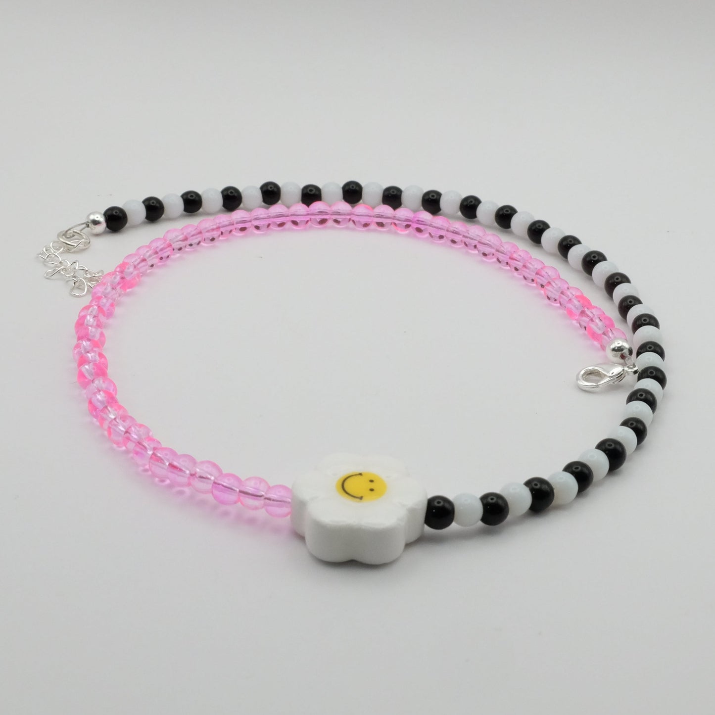 Beaded bracelet with pink and black beads on a gray background