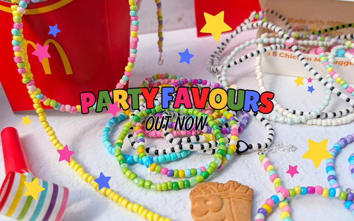 A collection of colorful beaded necklaces and bracelets styled as party favors, with a red McDonald's Happy Meal box, a striped party popper, and a chocolate biscuit cookie. A large text overlay reads 'PARTY FAVOURS OUT NOW'.