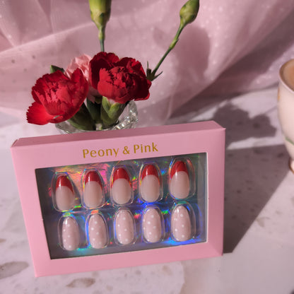 Pink nail polish set with flowers in a glass vase on a textured surface