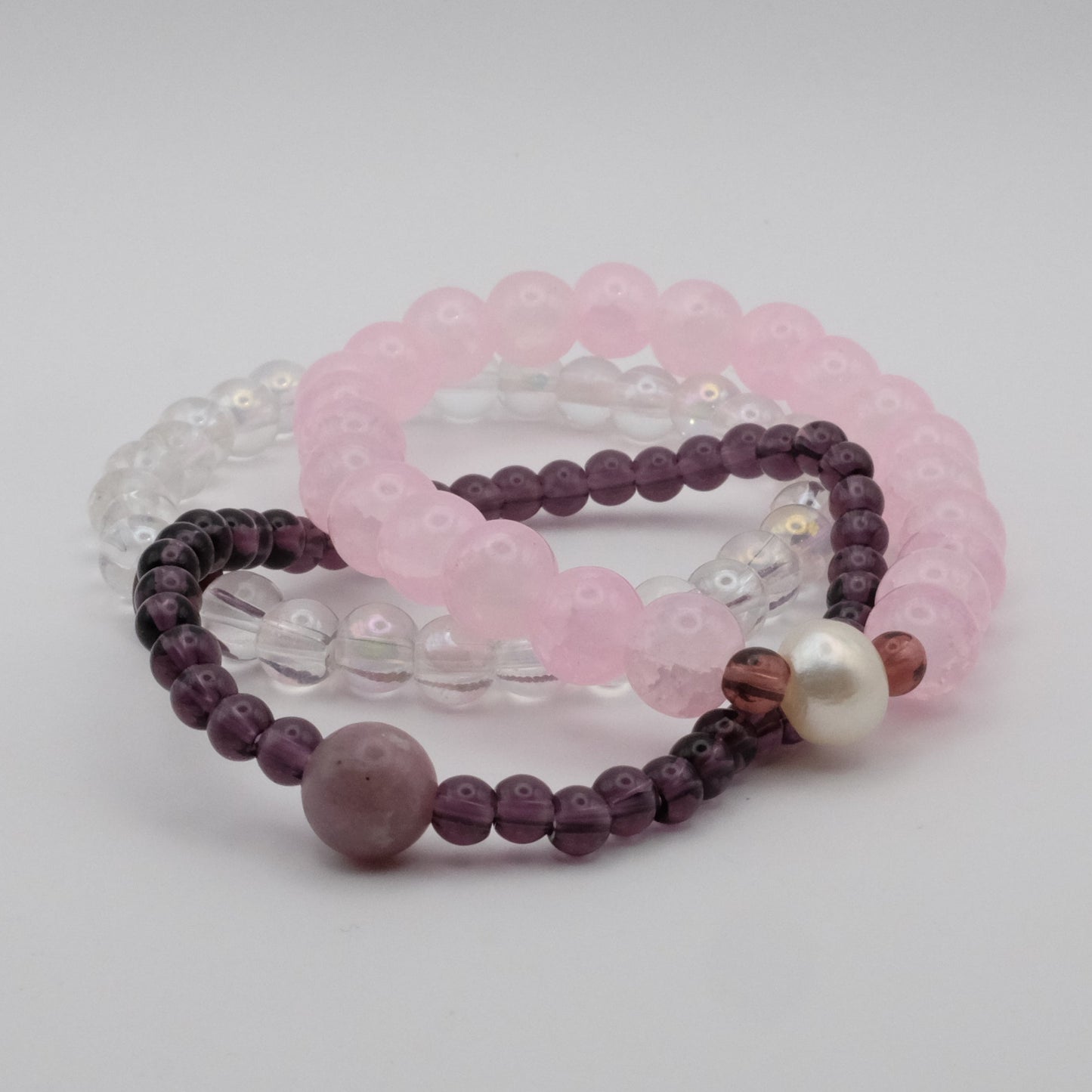 Set of three beaded bracelets on a light gray background