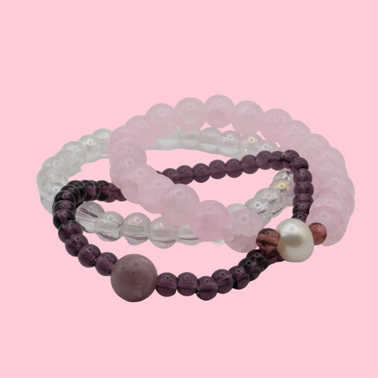 One-of-a-kind bracelet stack featuring blush pink glass beads, clear crystal beads, freshwater pearls and soft plum accents from the Satin Static collection.
