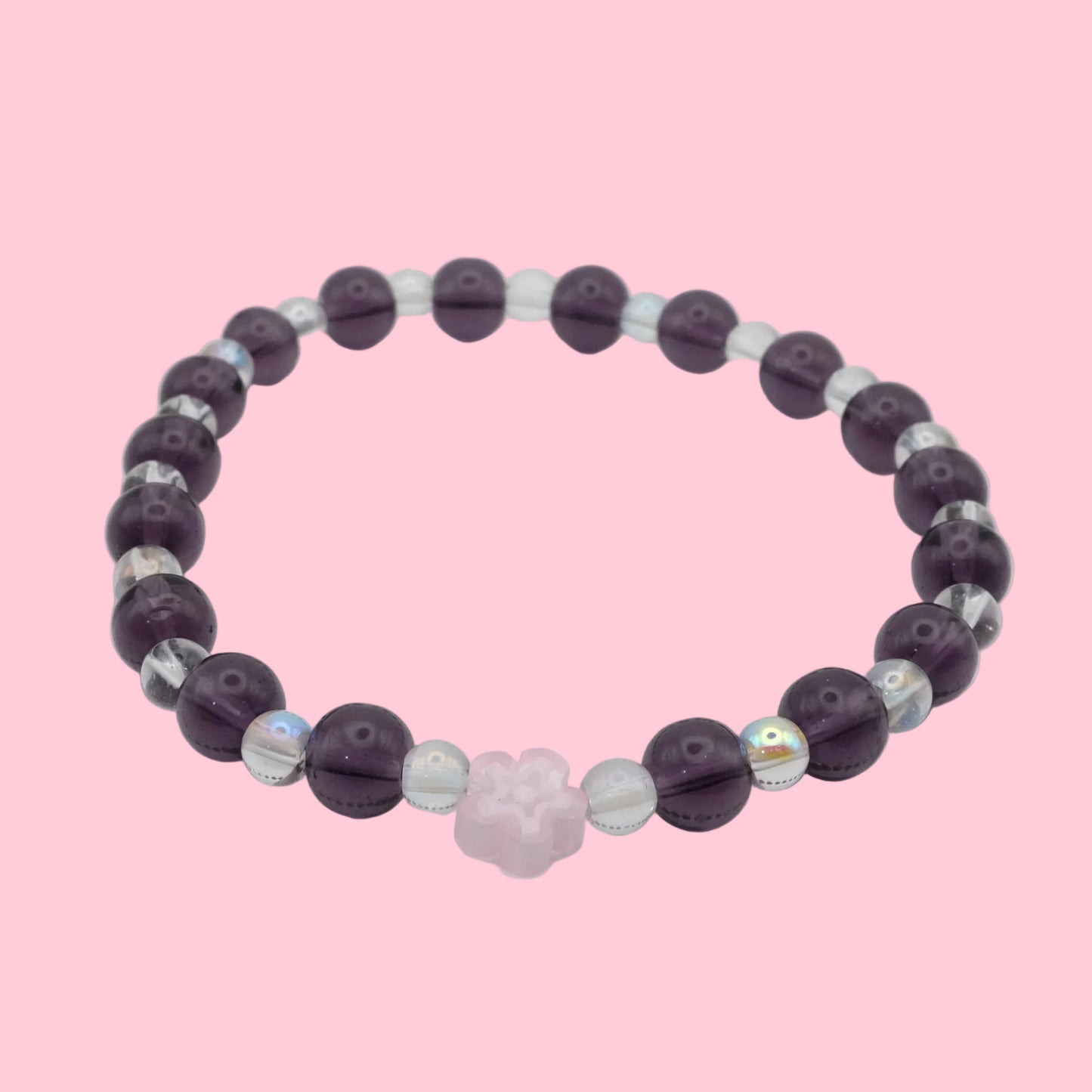 An elastic beaded bracelet composed of alternating 6mm deep purple glass beads and 4mm clear iridescent glass beads, featuring a soft pink glass flower bead at the centre, shown on a white background.