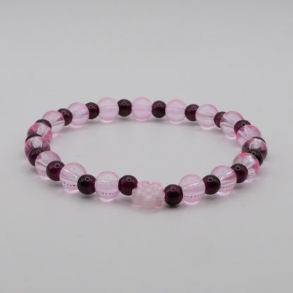Beaded bracelet with pink and purple beads on a light gray background