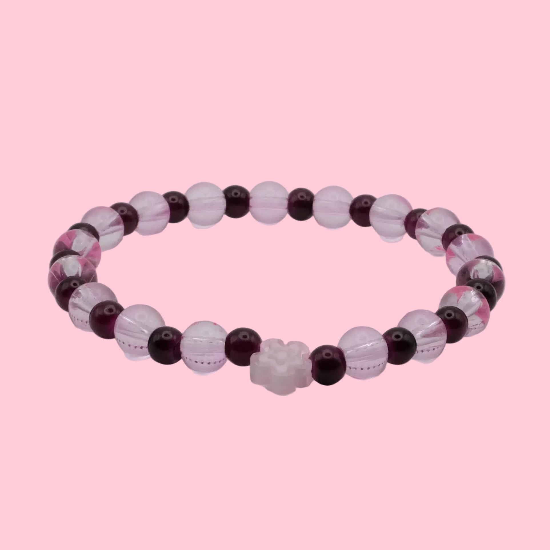 An elastic beaded bracelet composed of 6mm translucent blush pink beads and deep burgundy beads, featuring a single pale pink flower bead at the centre, shown on a clean white background.