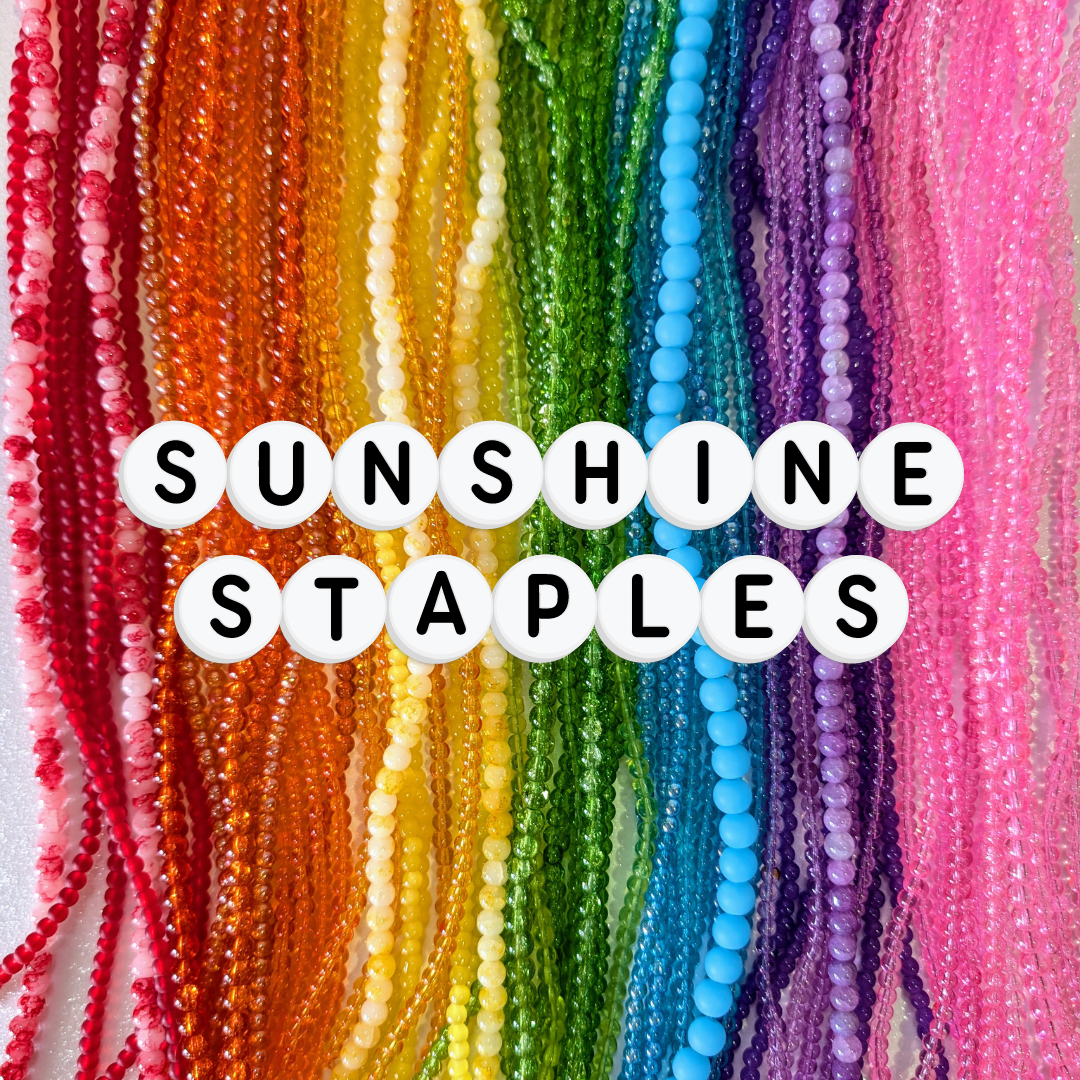 Rows of vibrant glass beads in rainbow shades of red, orange, yellow, green, blue, purple, and pink, with white acrylic letter beads spelling “Sunshine Staples.” A core handmade jewellery range perfect for dopamine dressing, colourful accessories, and Gold Coast handmade jewellery lovers.