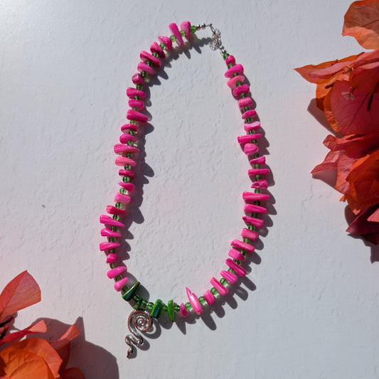 Colourful handmade necklace with bright pink shell chips, green glass beads and a silver snake charm.