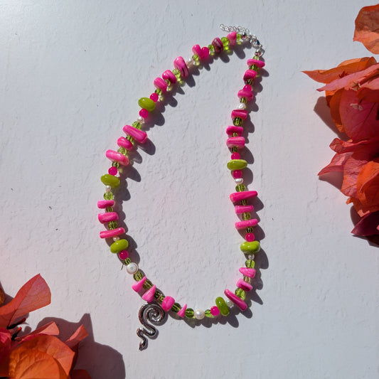 One-of-a-kind pink and green beaded necklace with shell chips, glass beads, pearl details and a silver snake charm.